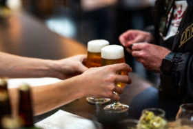 Pair of hands picking glasses of beer from a bar