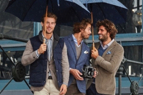 Models in suits and puffer jacket holding umbrellas