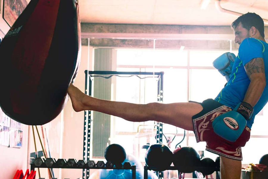 Man kicking punching bag