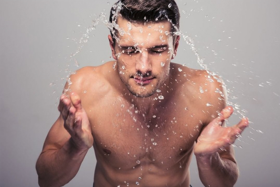 Man splashing water on face