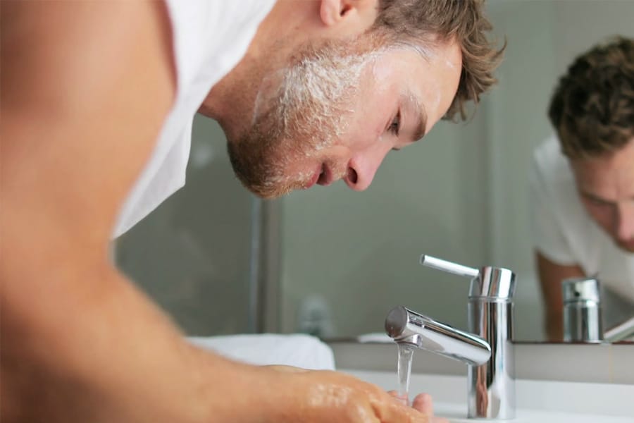 man washing face