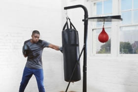 A man punching punching bag hanging by Aldi Boxing Toer