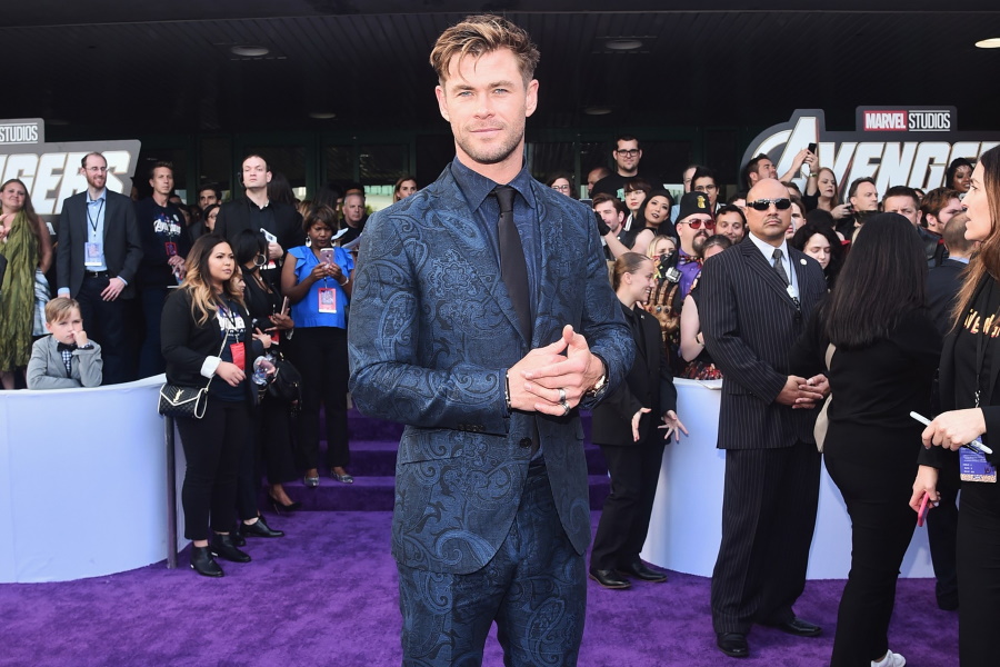Medium shot of Chris Hemsworth wearing a blue patterned suit on the purple carpet for the Avengers Endgame world premiere