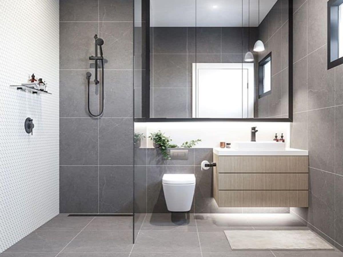 bathroom with large slate tiles and shower area with small hexagons white wall