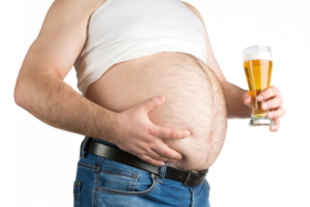 A man with a big belly holding a beer glass
