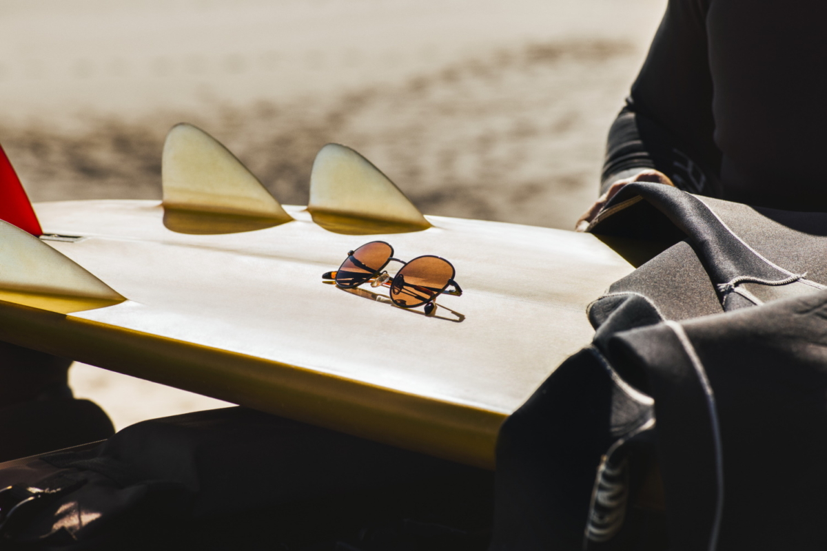 Sunglasses on a turned over surfboard