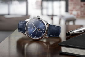 A blue dial Longines watch on its side