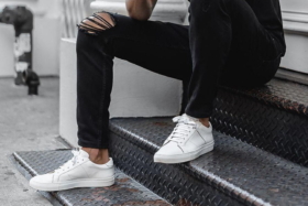 Legs of a model in black jeans and white sneaker