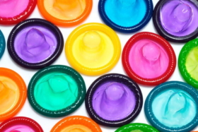 Different colour condoms on a white background