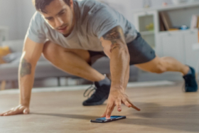 A man touching his phone screen while working out
