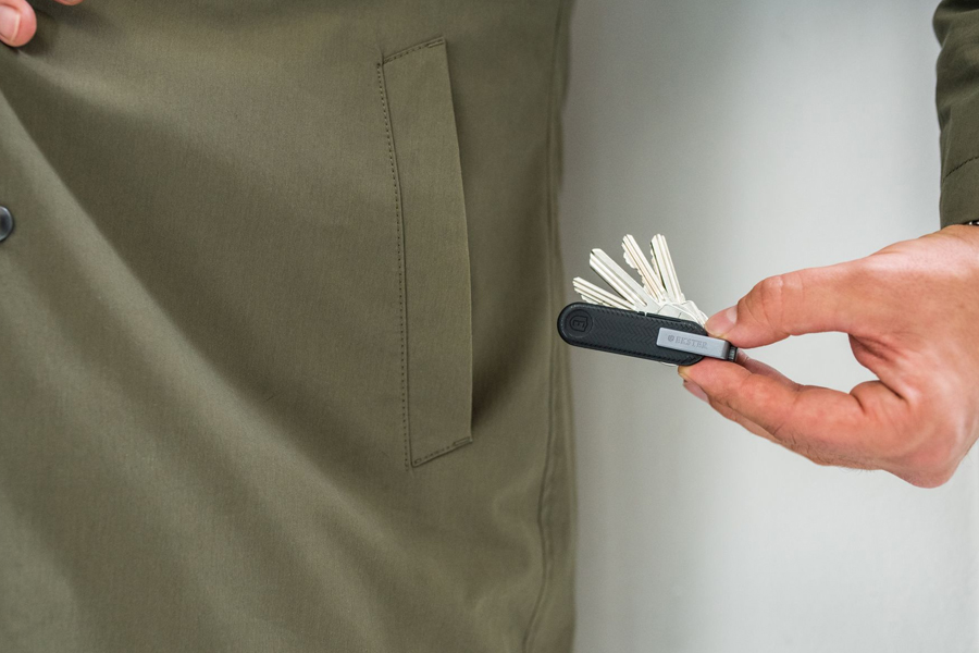 Close up of a hand putting the Ekster key holder into a pocket