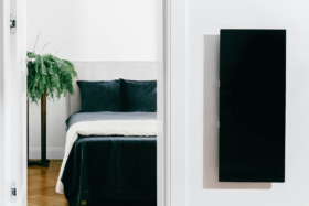 A bedroom and KOLEDA SOLUS+ heater on a wall