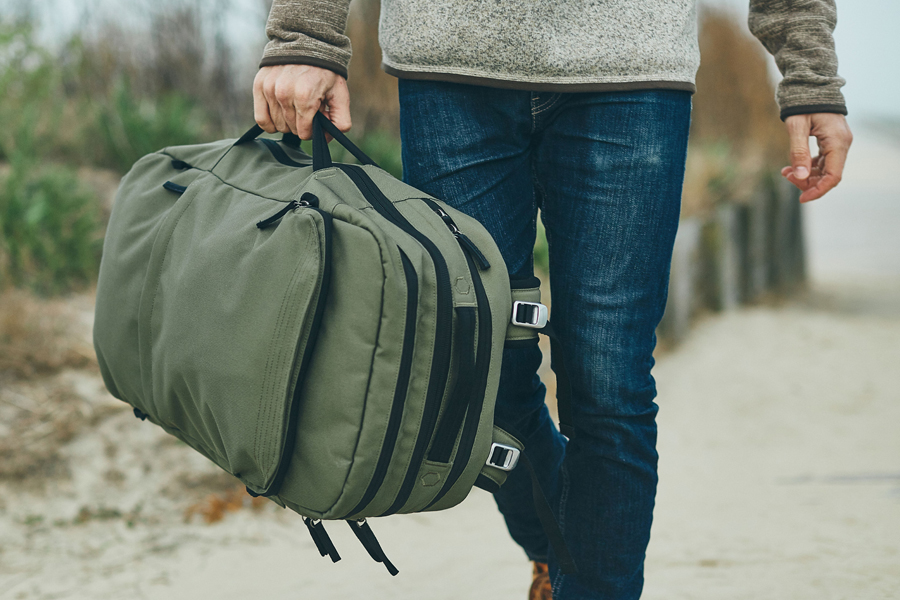 Pakt Travel Backpack in a man's hand