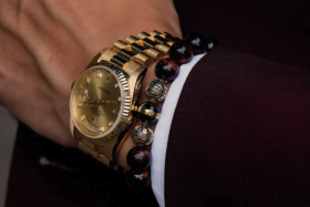 A man's wrist with Rolex watch and Azuro Republic beaded bracelet