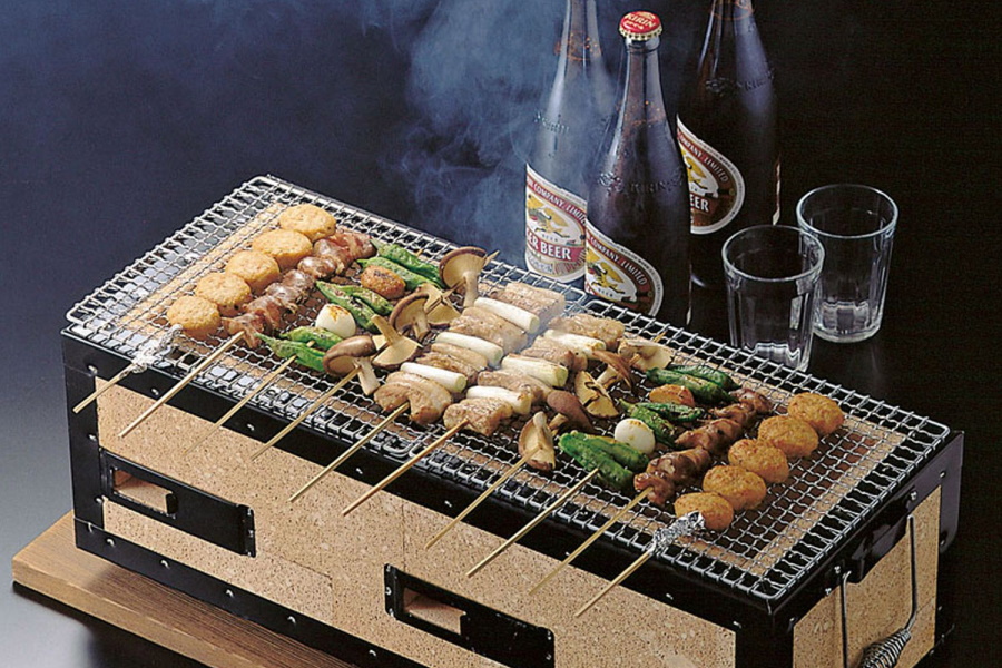 Food skewers on a Hibachi grill and bottles of beer