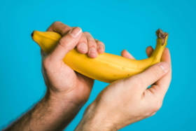 A pair of hands holding a banana