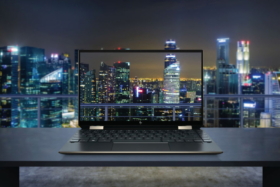 HP Spectre x360 laptop with a city's night skyline in background