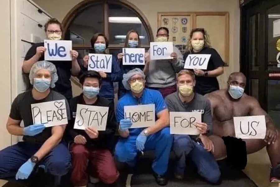 Edited photo of naked Barry Wood with healthcare professionals wearing face masks and holding a sign that reads 'We Stay here For You Please Stay Home For Us'