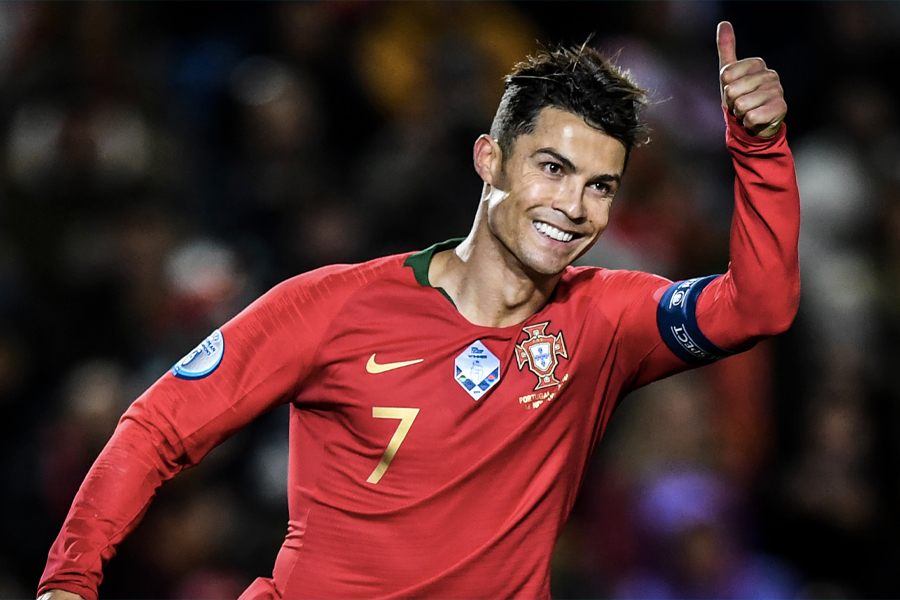 Medium shot of Cristiano Ronaldo in red jersey smiling and doing a thumbs up
