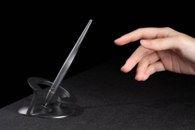 A hand about to pick up Hoverpen from its stand