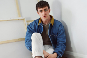 A model in a denim jacket and white pants