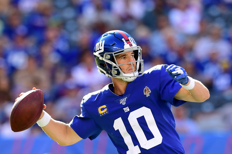 Eli Manning in his football gear throwing a football