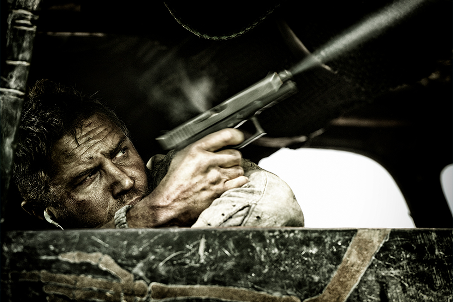 Tom Hardy shooting with a gun from Mad Max Fury Road
