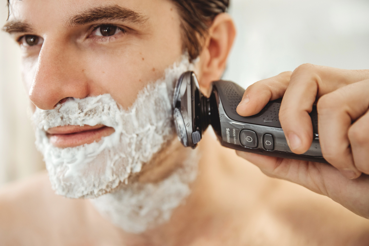 A man shaving his beard with Philips Series 6000 shaver