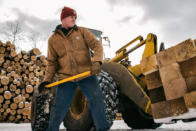 A lumberjack with a hammer wearing a Carhartt jacket
