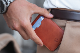 A hand putting Vaultskin RFID Blocking wallet in a pants pocket