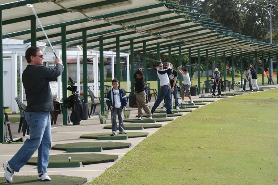 People in tee boxes at Oxley Driving Range Complex