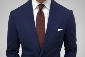 A torso of a man in suit with Dark Knot accessories
