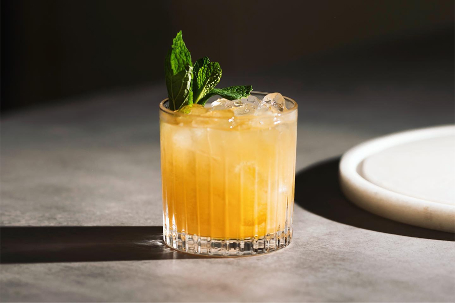 A yellow cocktail in a glass