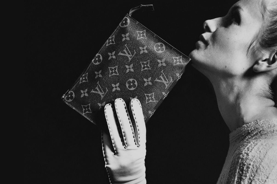 Woman wearing a glove holding a Louis Vuitton purse