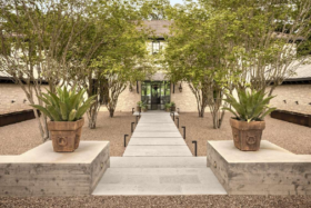 Paved path towards the door of Joe Rogan's Texas Ranch with plants on both sides