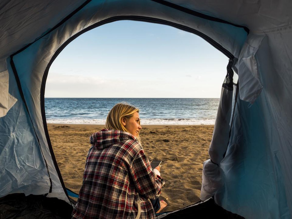 young woman sitting on the tent and looking on the ocean at mornington peninsula foreshore