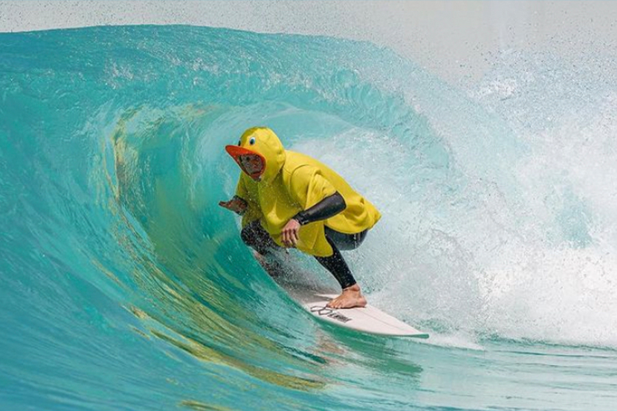 A man surfing in a rubber duck jacket