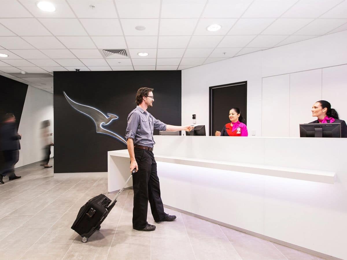 A man interacting with lounge staff at airport