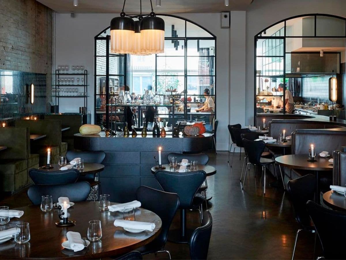 Interior of Cutler & Co. restaurant with black and white colour scheme showing tables and chairs with customers dining