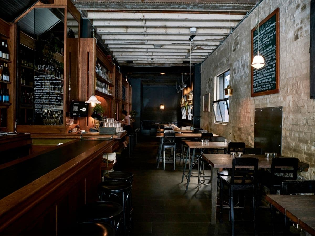 Interior of Embla restaurant with dark wood and black colour scheme showing tables and chairs