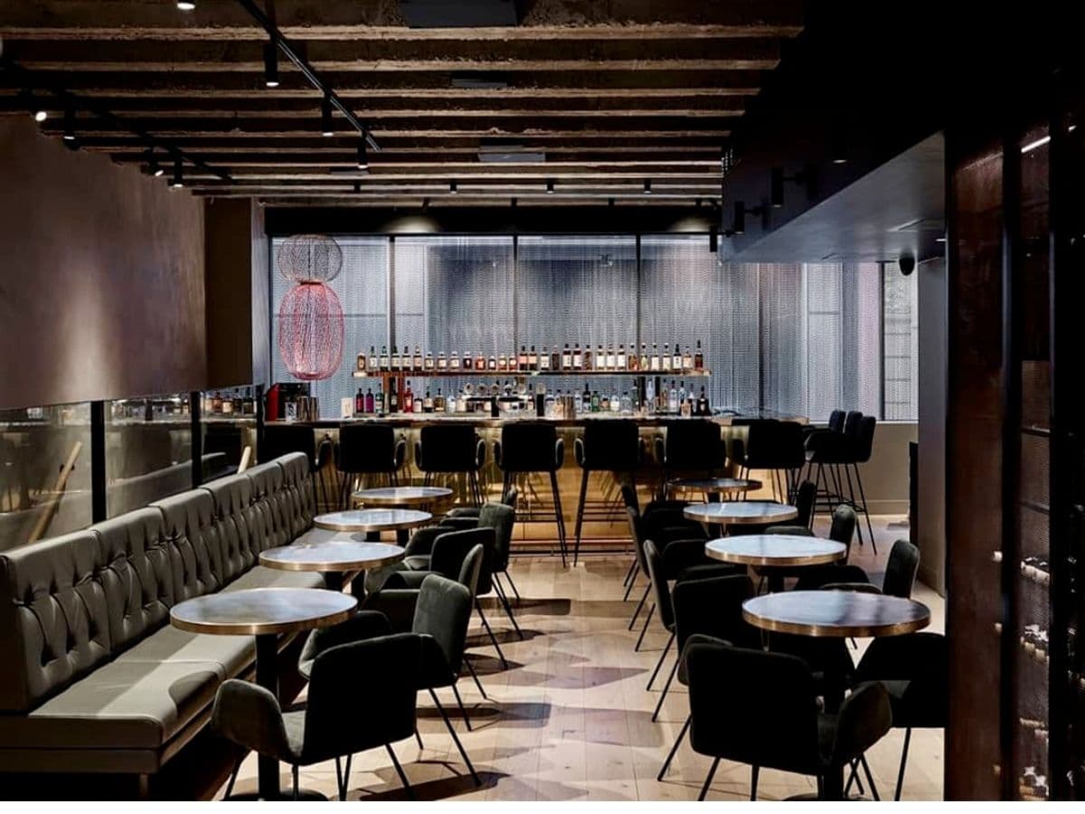 Interior of Kisume restaurant with dark and red colour scheme showing tables, chairs, bar counter with stools, and wide windows