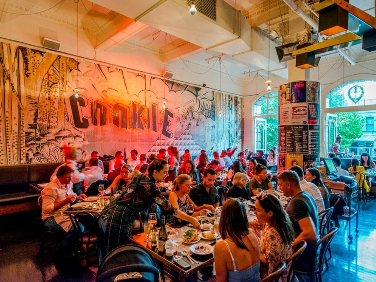 Interior of Cookie restaurant with bright neon colour scheme showing customers dining