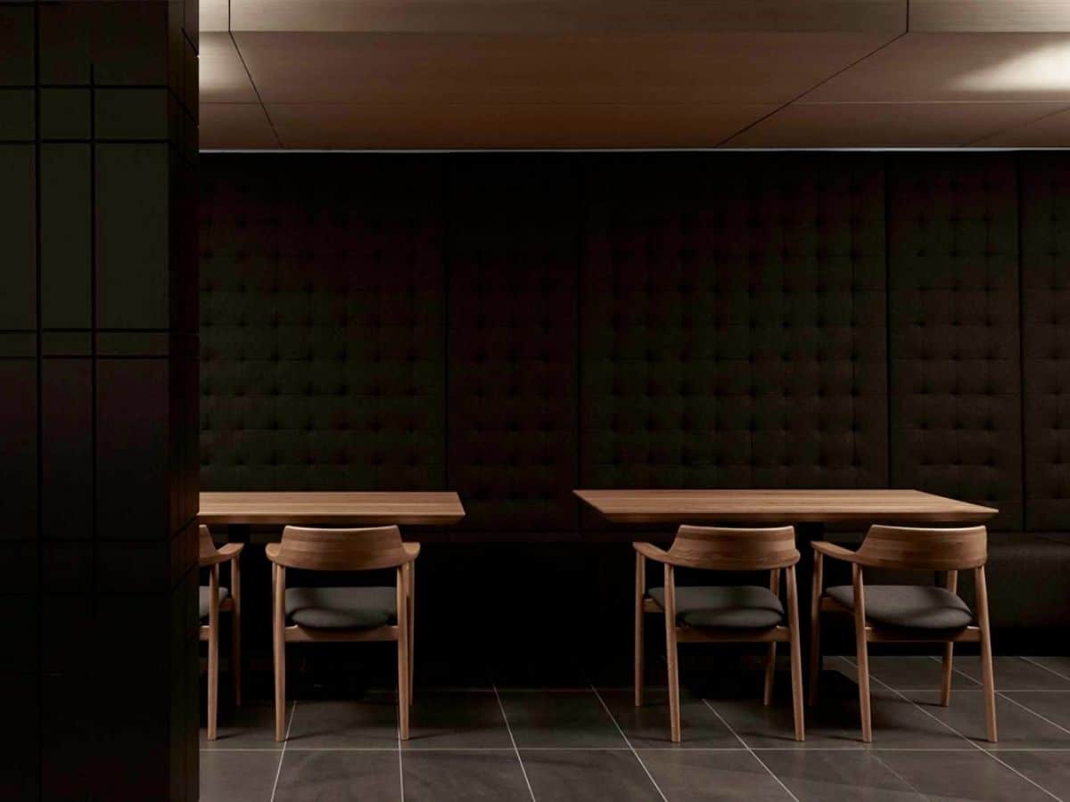 Interior of Minamichima restaurant with dark colour scheme showing wooden tables and chairs