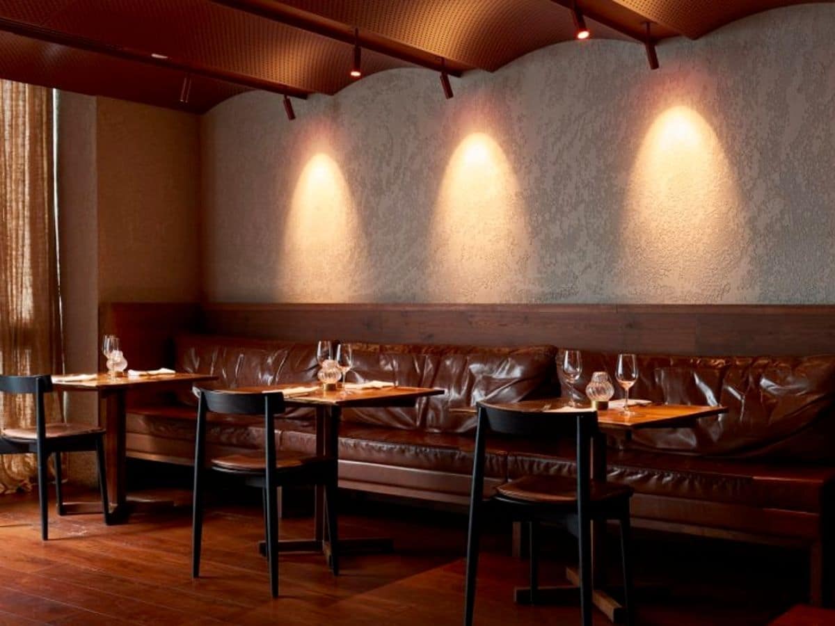 Interior of Minamichima 159 Domain restaurant with rust, grey and black colour scheme showing tables and chairs