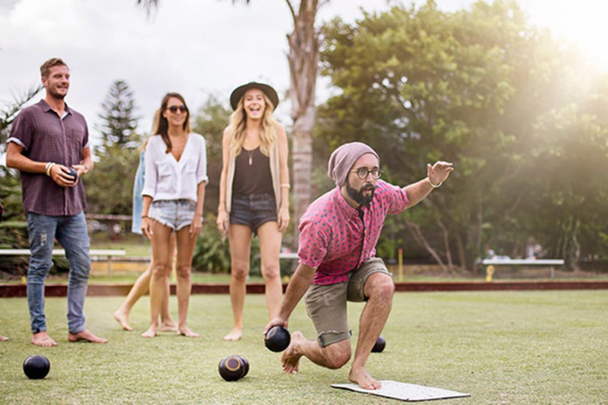 Man bowling as people look at him in background