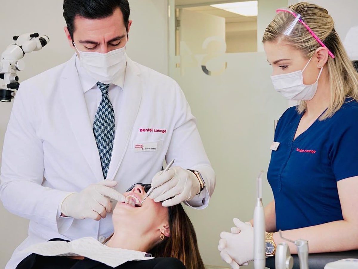 doctor treats patient teeth at dental lounge clinic