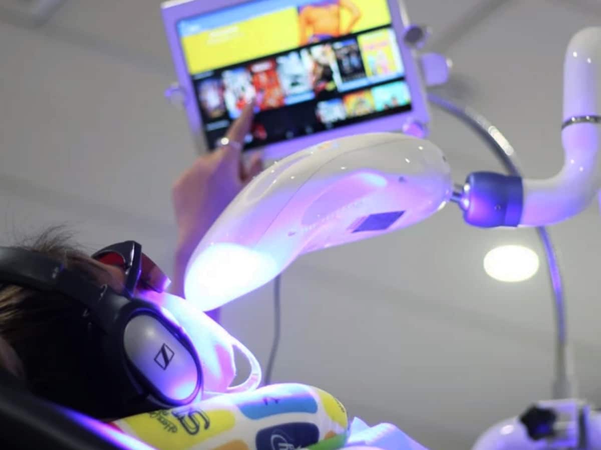 patient lies in dental chair and looks at tooth monitor at smile labs