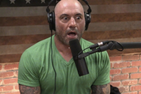 Shocked Joe Rogan with an open mouth in front of a microphone