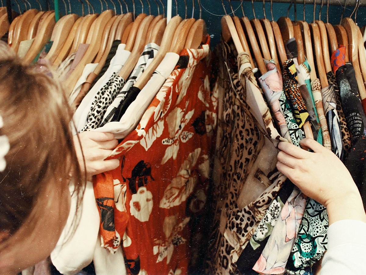 woman browsing through vintage clothing thrift