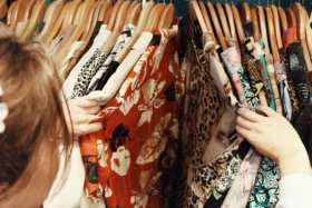woman browsing through vintage clothing thrift
